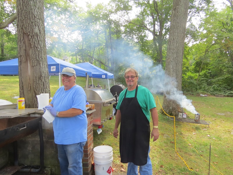 BBQ crew grilling at Boobstock with smoke rising