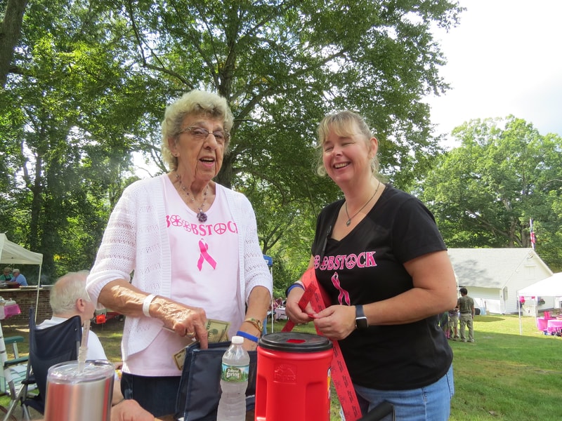 Two women in Boobstock shirts at the raffle table
