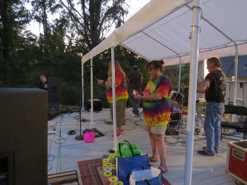 People on stage in tie-dye shirts at Boobstock